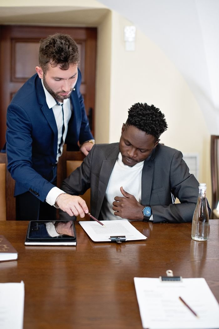 Two businessmen collaborating on a project at an office table.